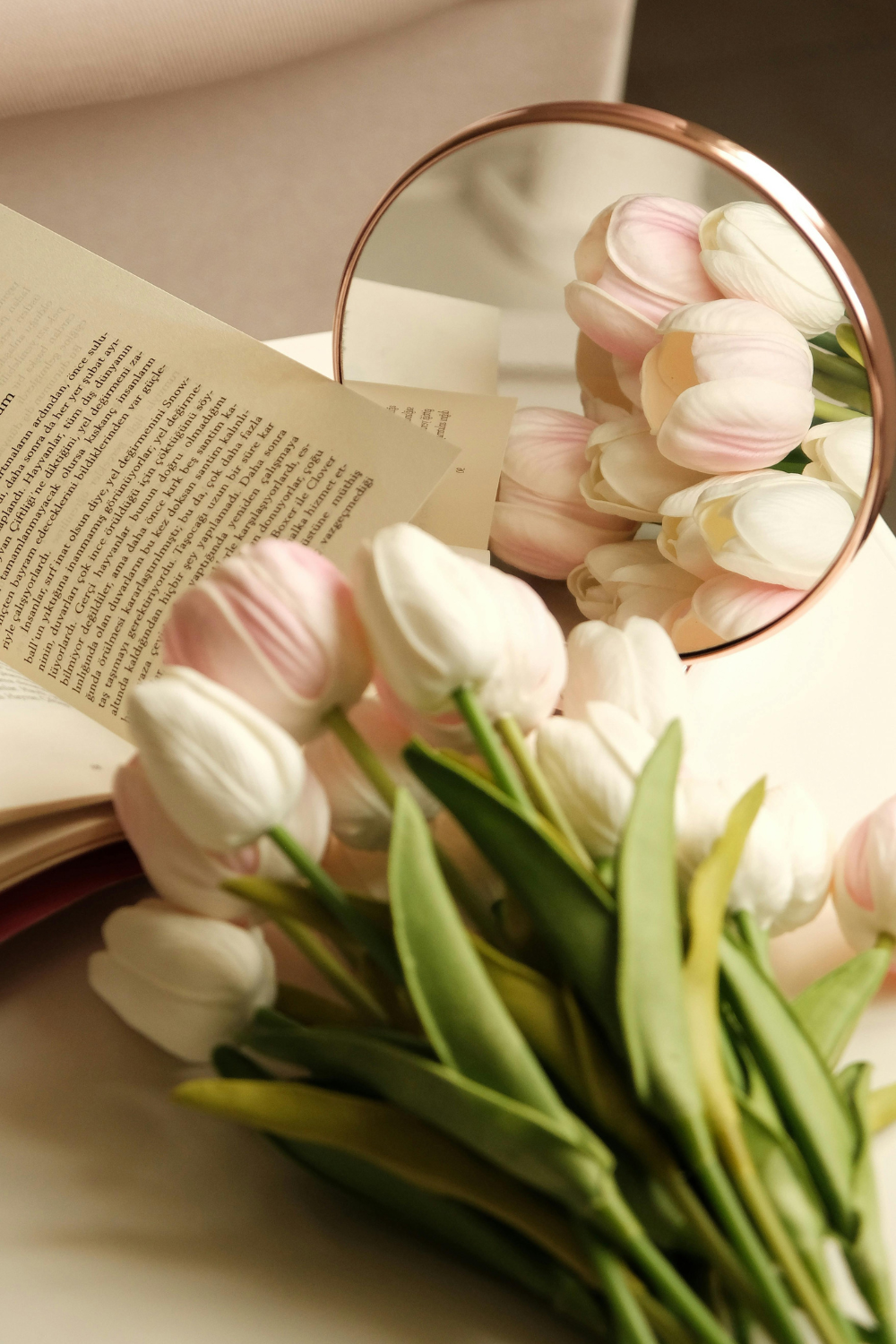 Resting Tulips on a surface with a Small Mirror and Open Book