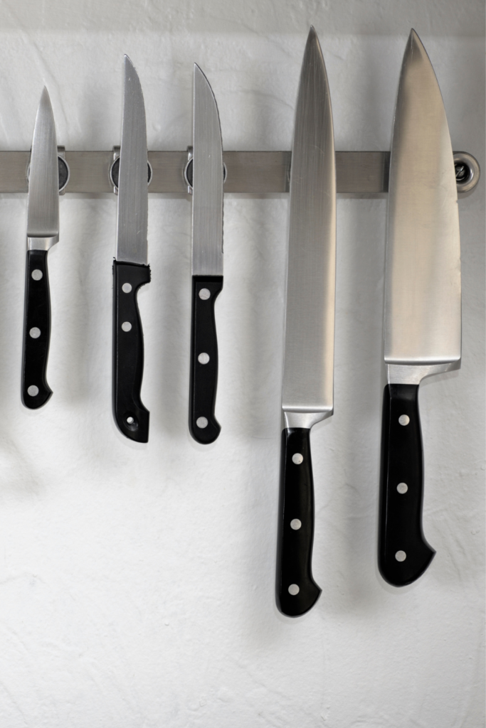 Close-up of magnetic knife strip wall mount with stainless steel knives