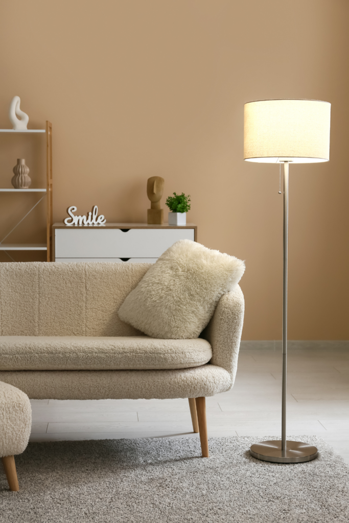 Modern floor lamp with warm lighting in a living room, creating a cozy spring atmosphere.
