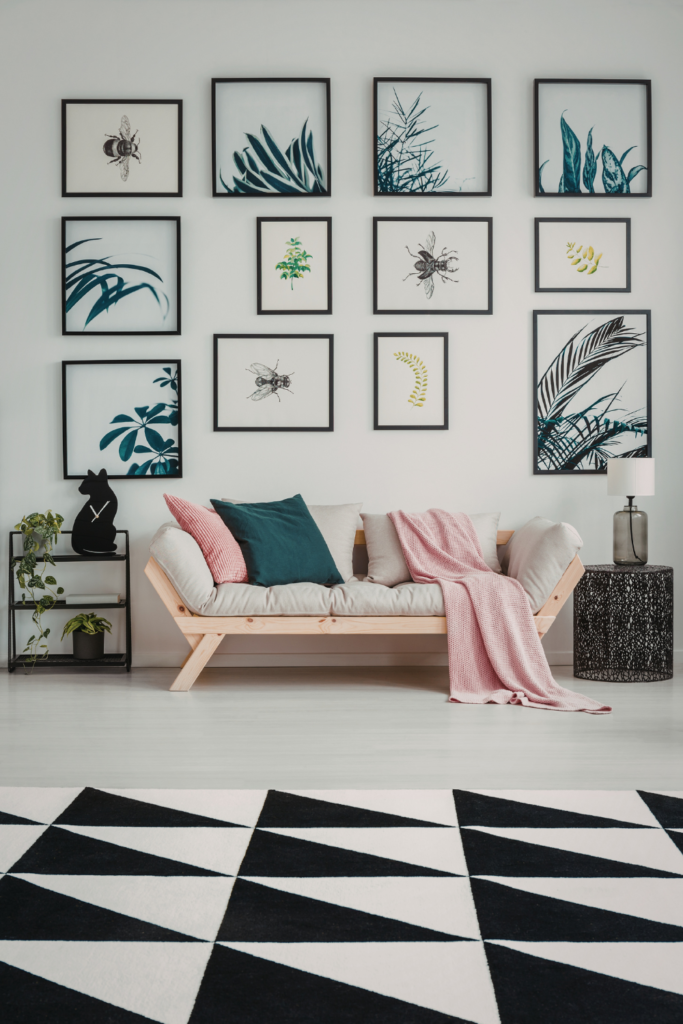Assorted wall art including abstract prints and framed photography displayed on a living room wall, adding stylish, modern, and budget-friendly home decor.